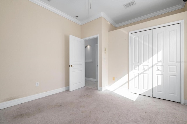 unfurnished bedroom with light colored carpet, crown molding, and a closet