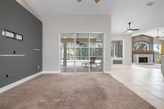 unfurnished living room with light carpet, a fireplace, and vaulted ceiling