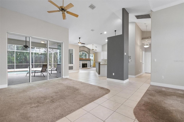 unfurnished living room featuring ceiling fan, light colored carpet, a fireplace, and a high ceiling