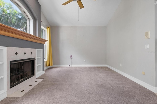 unfurnished living room featuring ceiling fan, a fireplace, light colored carpet, and lofted ceiling