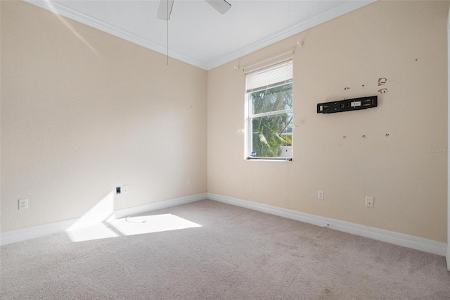 carpeted spare room featuring ceiling fan and crown molding