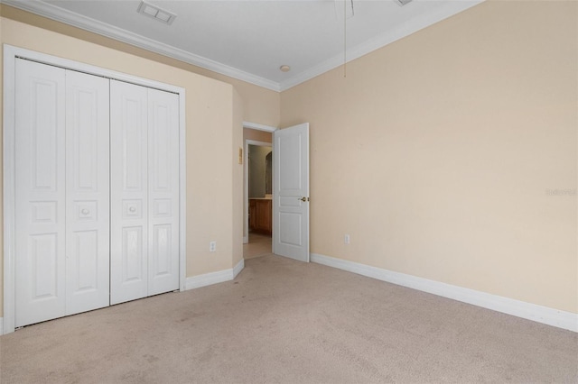 unfurnished bedroom with crown molding, light carpet, and a closet