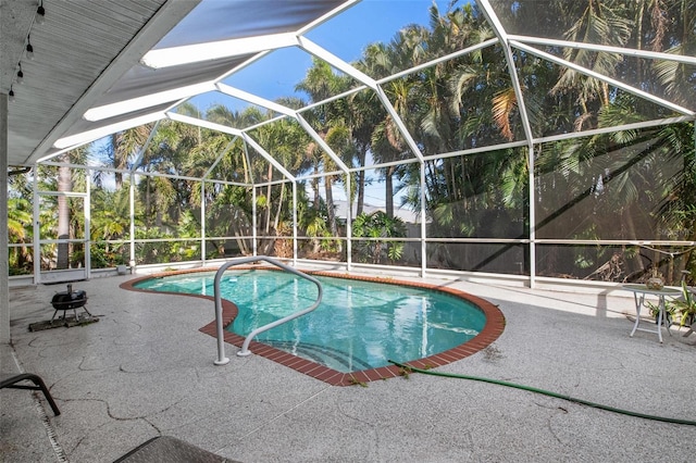 view of swimming pool featuring glass enclosure and a patio