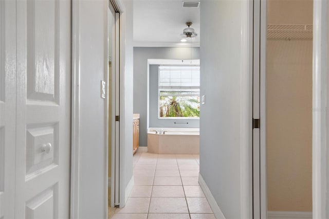 hall with light tile patterned floors and crown molding