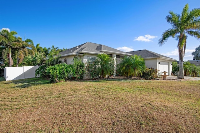 ranch-style house featuring a garage and a front lawn