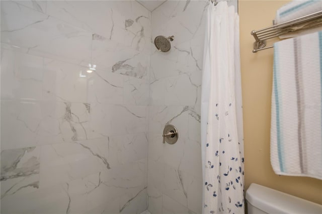 bathroom featuring toilet and a shower with shower curtain