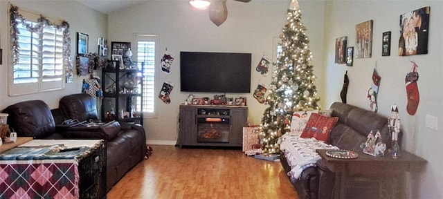 living room featuring wood-type flooring, vaulted ceiling, and ceiling fan