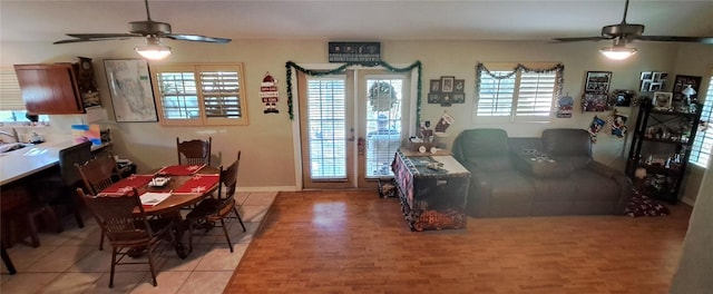 tiled dining space featuring ceiling fan and french doors