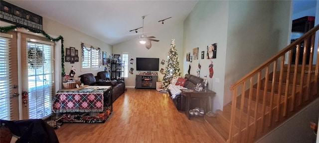 living room featuring ceiling fan, track lighting, wood-type flooring, and vaulted ceiling