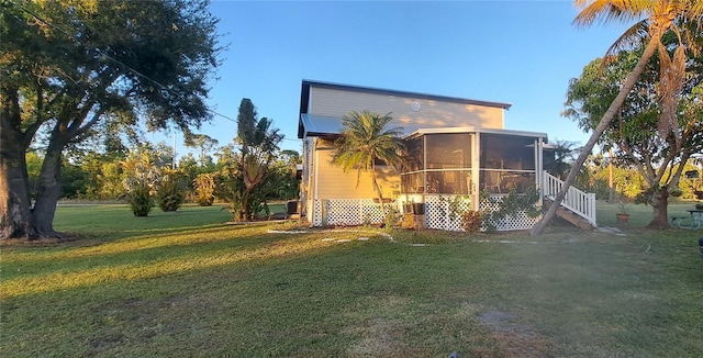 view of side of home featuring a sunroom and a yard