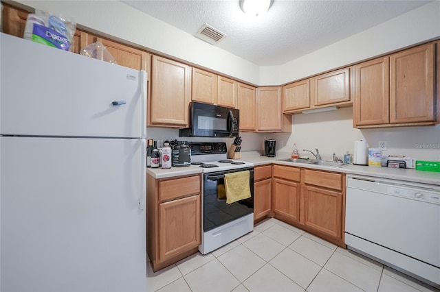 kitchen with a textured ceiling, white appliances, light tile patterned floors, and sink