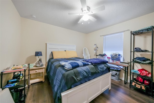 bedroom featuring ceiling fan, dark hardwood / wood-style floors, and a textured ceiling