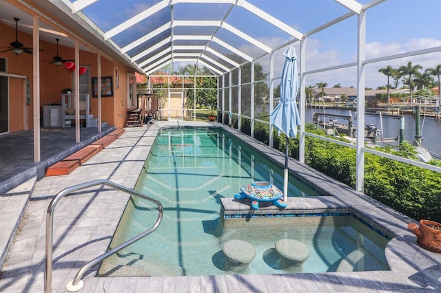 view of swimming pool featuring a lanai, ceiling fan, a water view, and a patio