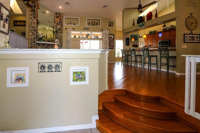 stairs featuring hardwood / wood-style flooring and ceiling fan