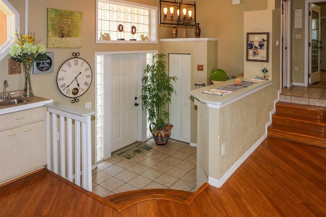 tiled entryway featuring sink and a notable chandelier