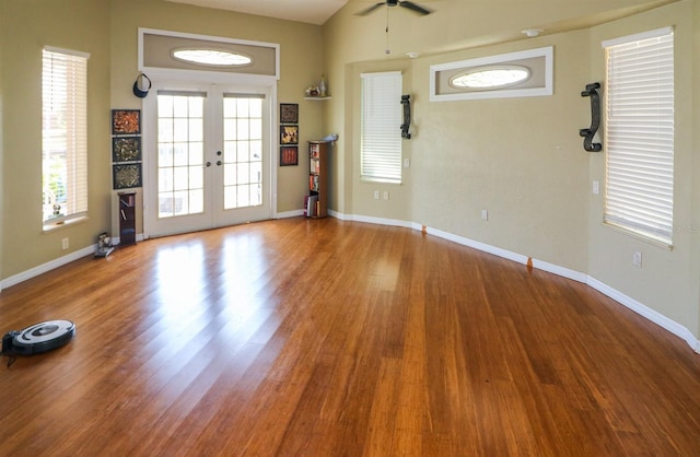 interior space with ceiling fan, french doors, and wood-type flooring