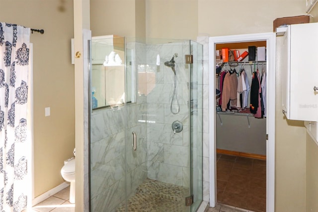 bathroom featuring toilet, tile patterned floors, and a shower with door