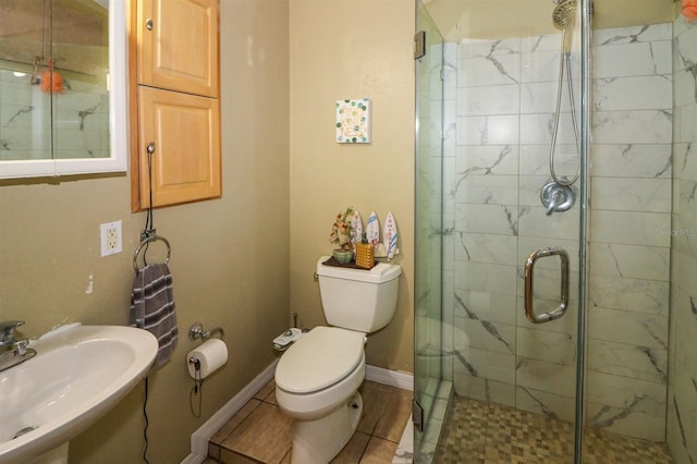 bathroom with tile patterned floors, sink, an enclosed shower, and toilet