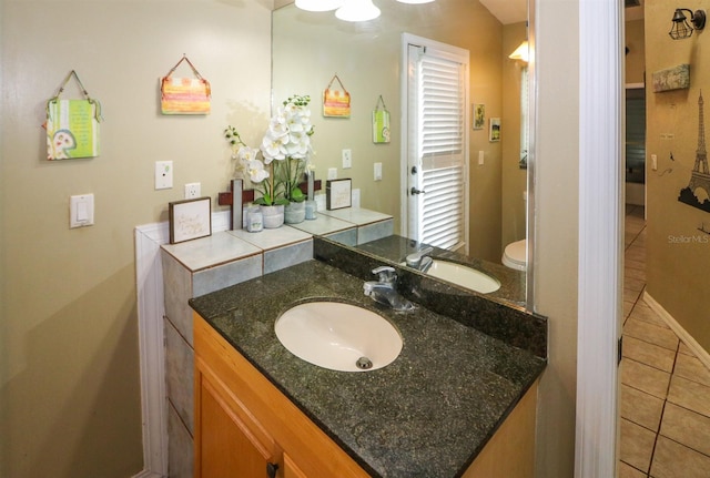 bathroom with tile patterned flooring, vanity, and toilet