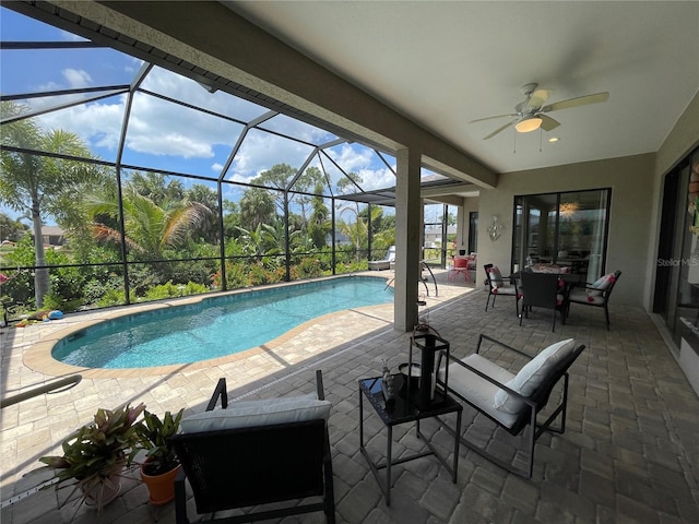 view of pool featuring ceiling fan, a patio area, and glass enclosure