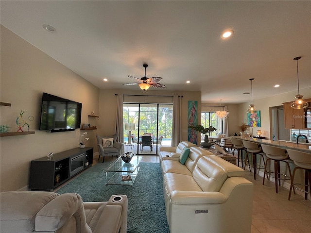 living room with sink, light tile patterned floors, and ceiling fan