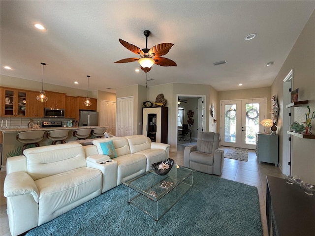 living room with light tile patterned floors, ceiling fan, and french doors