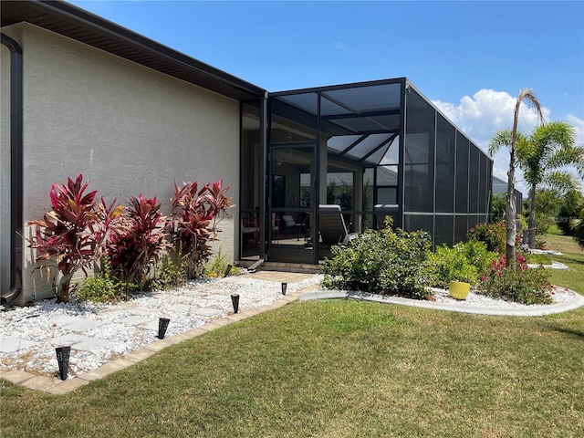 back of property with a yard and glass enclosure