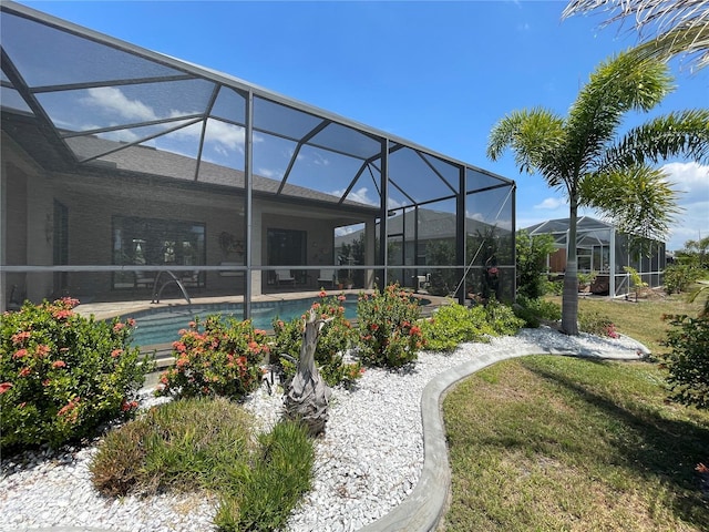 exterior space with pool water feature, glass enclosure, and a lawn