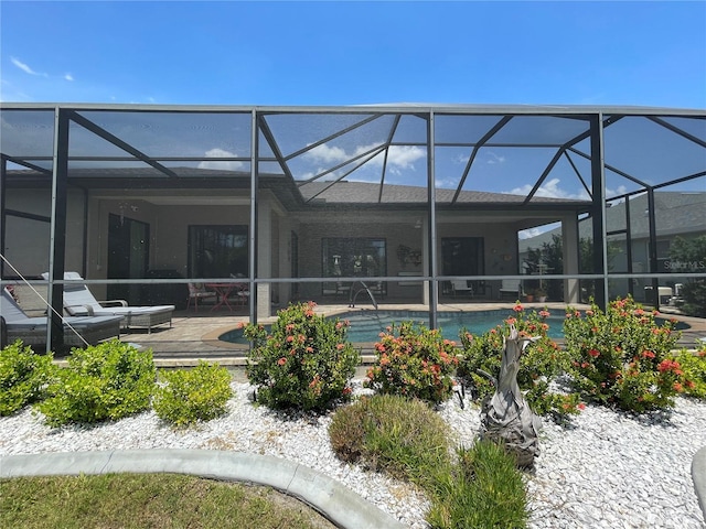 back of house with a lanai and a patio area