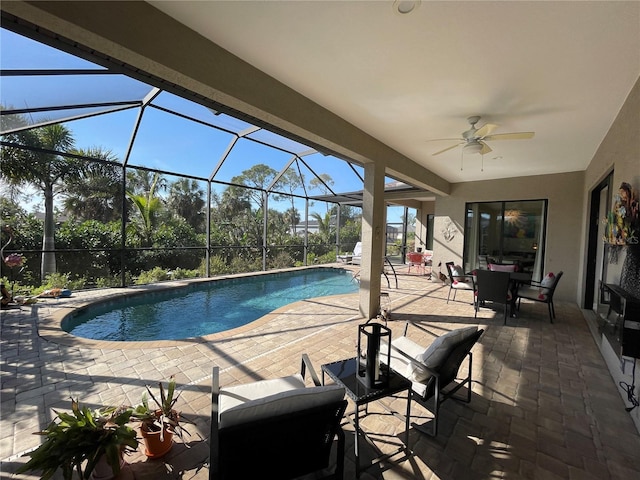 view of pool with a patio, ceiling fan, and glass enclosure