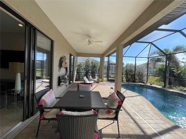 view of pool with ceiling fan, glass enclosure, and a patio area