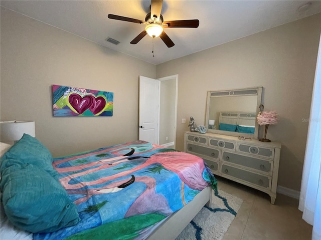 tiled bedroom featuring ceiling fan