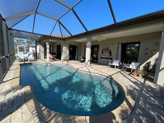 view of pool featuring a patio, ceiling fan, and glass enclosure