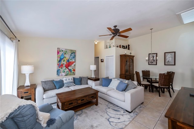 living room featuring ceiling fan, light tile patterned floors, and vaulted ceiling