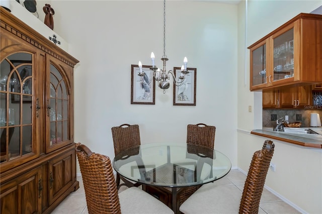 dining space with light tile patterned flooring, an inviting chandelier, and sink