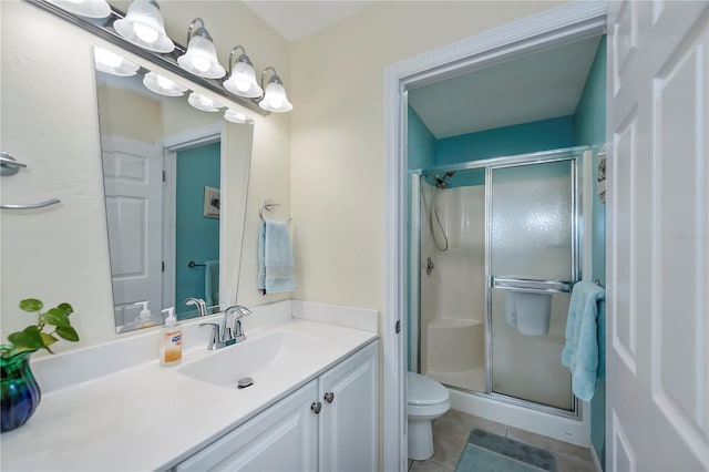 bathroom with toilet, vanity, tile patterned floors, and a shower with door