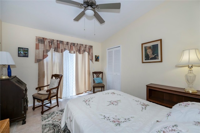 tiled bedroom with ceiling fan, a closet, and vaulted ceiling