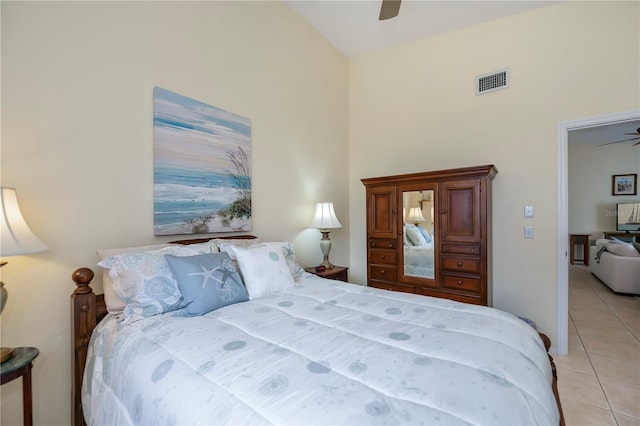 tiled bedroom with a towering ceiling and ceiling fan