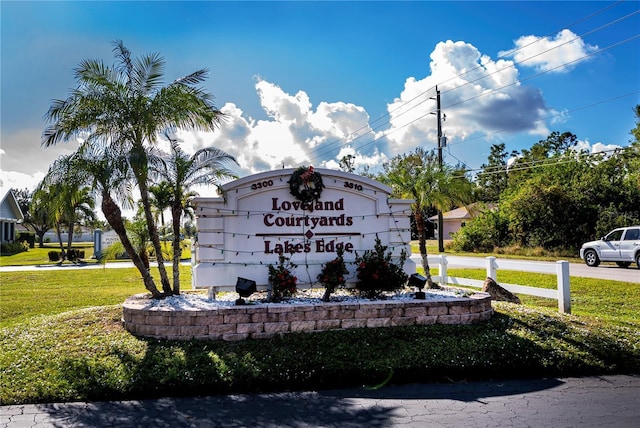 community / neighborhood sign featuring a yard