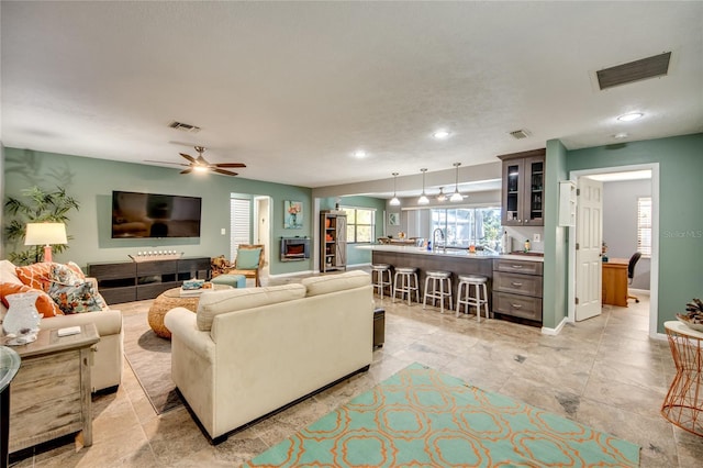 living room with ceiling fan and sink