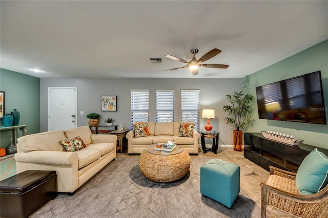 living room with a textured ceiling and ceiling fan