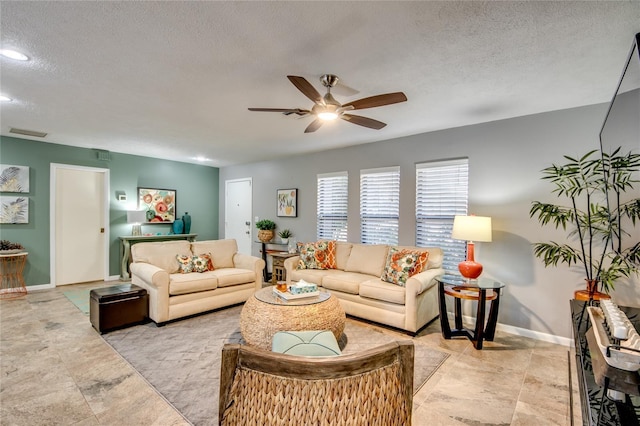 living room with ceiling fan and a textured ceiling