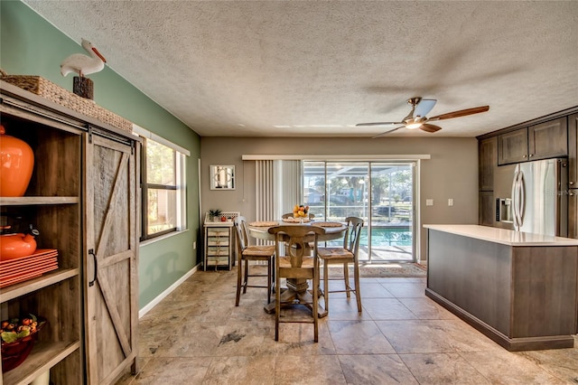 dining room with a wealth of natural light, ceiling fan, and a textured ceiling