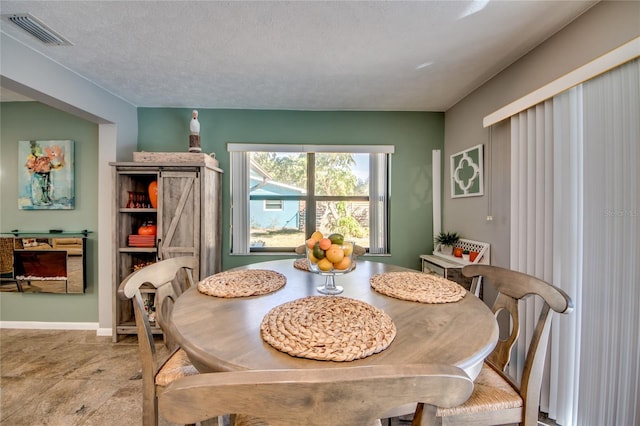 dining space with a textured ceiling and a barn door