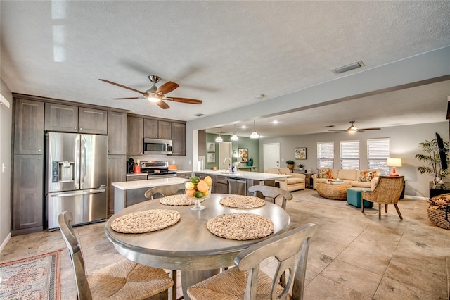 tiled dining space featuring ceiling fan and a textured ceiling