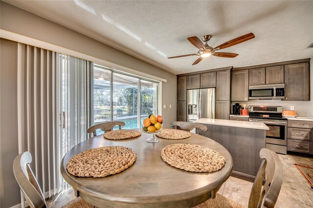 dining space with ceiling fan and a textured ceiling