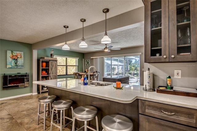 kitchen with a breakfast bar area, plenty of natural light, pendant lighting, and sink