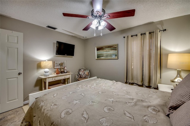 bedroom featuring ceiling fan and a textured ceiling