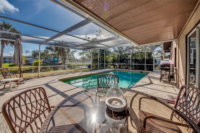 view of swimming pool featuring a lanai, area for grilling, and a patio area