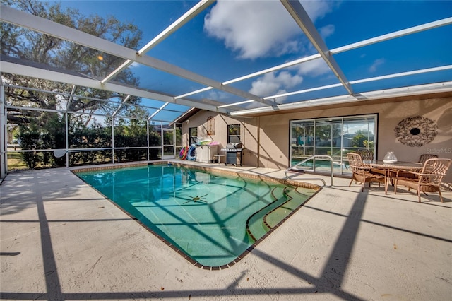 view of pool with glass enclosure and a patio